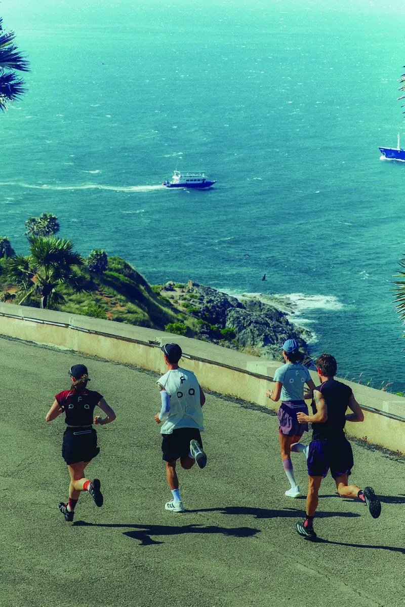 AEON® running group on a coastal road above a turquoise bay