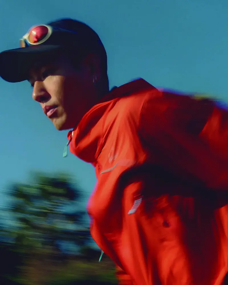 Close-up of a runner in a cap and red AEON® jacket